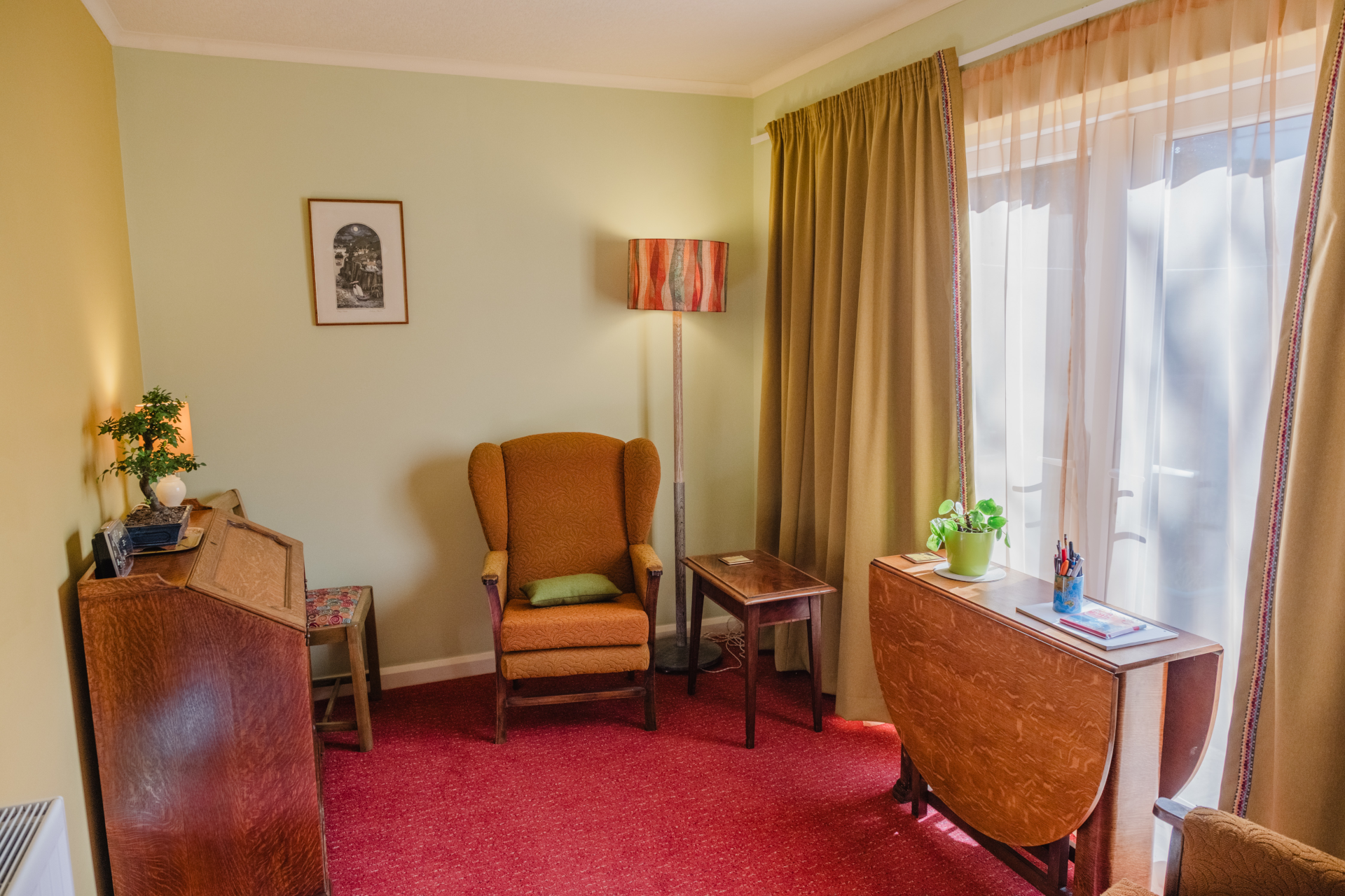 a walkway over a creek below a wooded slope
